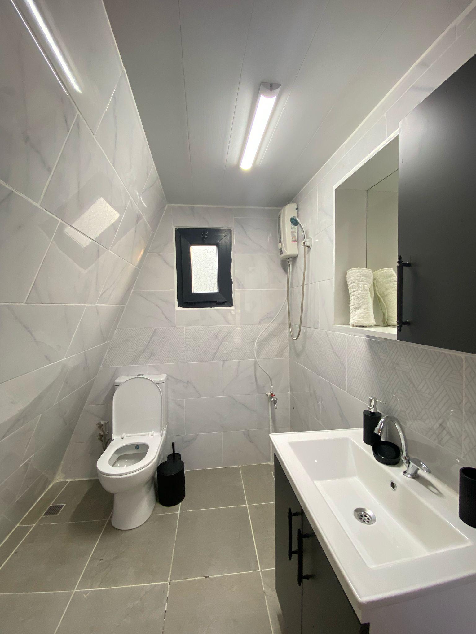 Modern ve şık bungalov iç mekanı, doğal ahşap mobilyalar, bej ve soft yeşil detaylar, rahat ve premium atmosfer