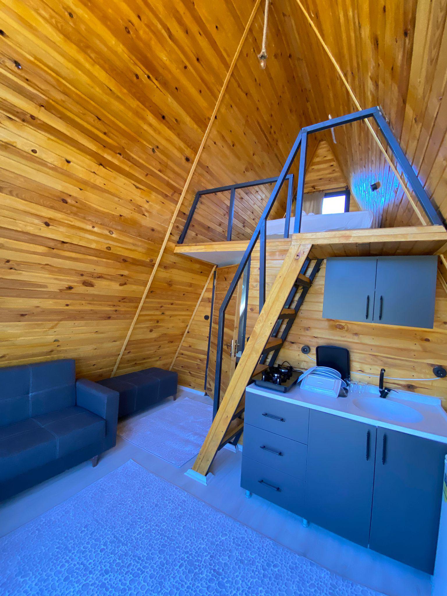 Gün doğumu sırasında bungalovlar, altın sarısı ve bej tonlarında gökyüzü, sıcak ve davetkar atmosfer